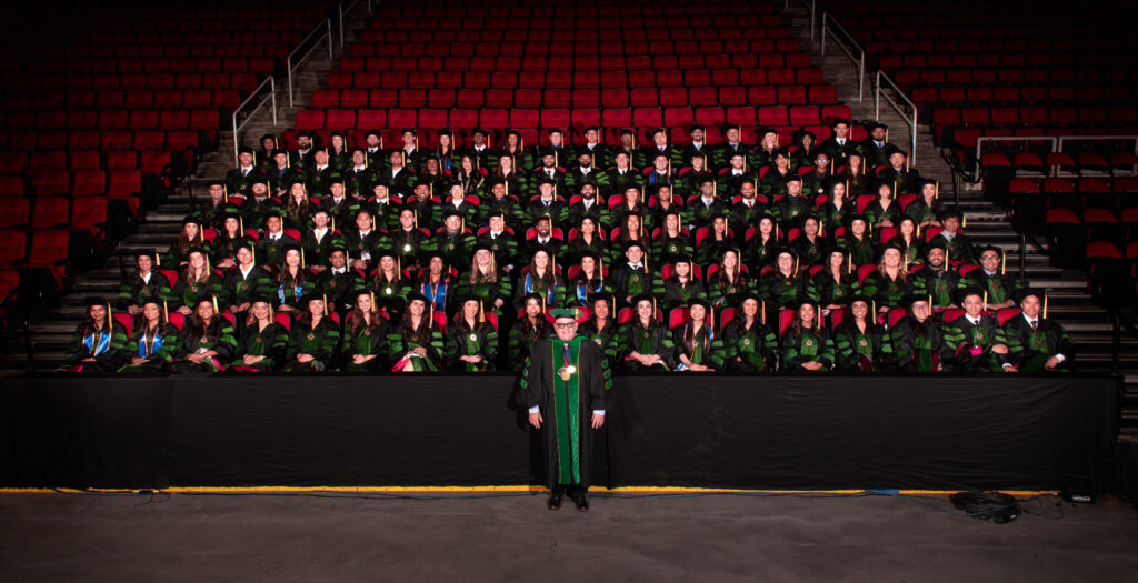 Class of 2025 Group photo in academic regalia seated in chairs