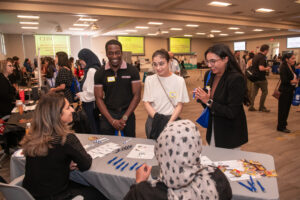 three students talking to residency program at fair