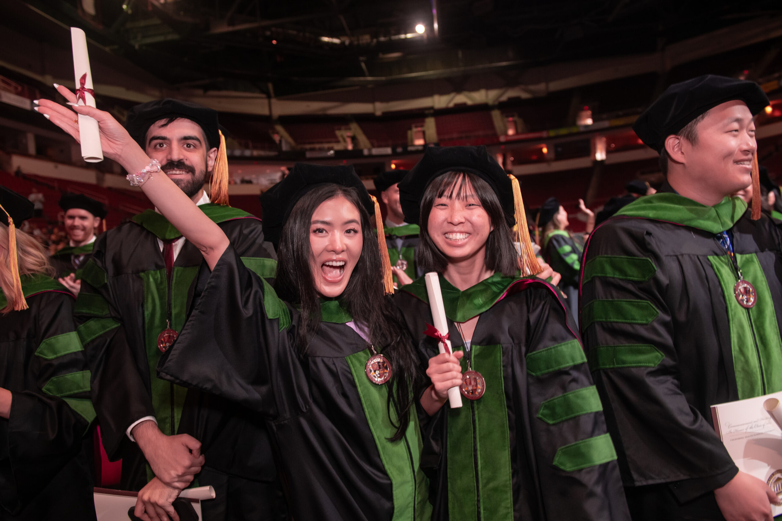 Graduates wearing academic regalia celebrate at Commencement