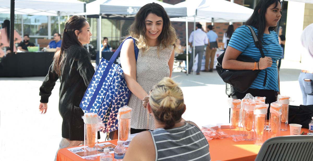 Student talking to woman at a table