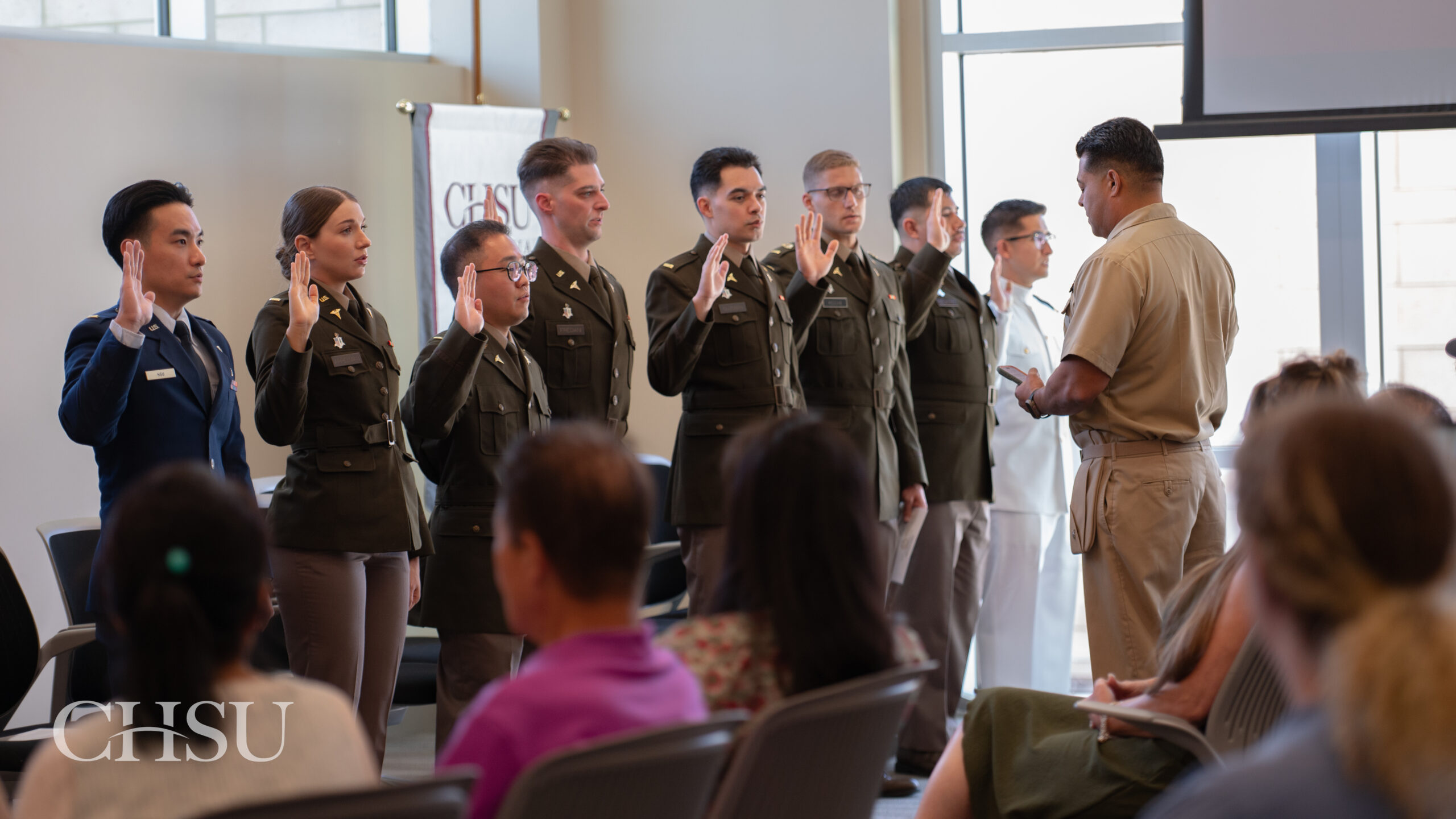 military officers graduation medical school standing in uniform raising right hand being sworn in for promotion in rank by Captain Bautista
