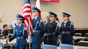 Clovis East Junior ROTC students wearing uniforms presenting the colors with US flag