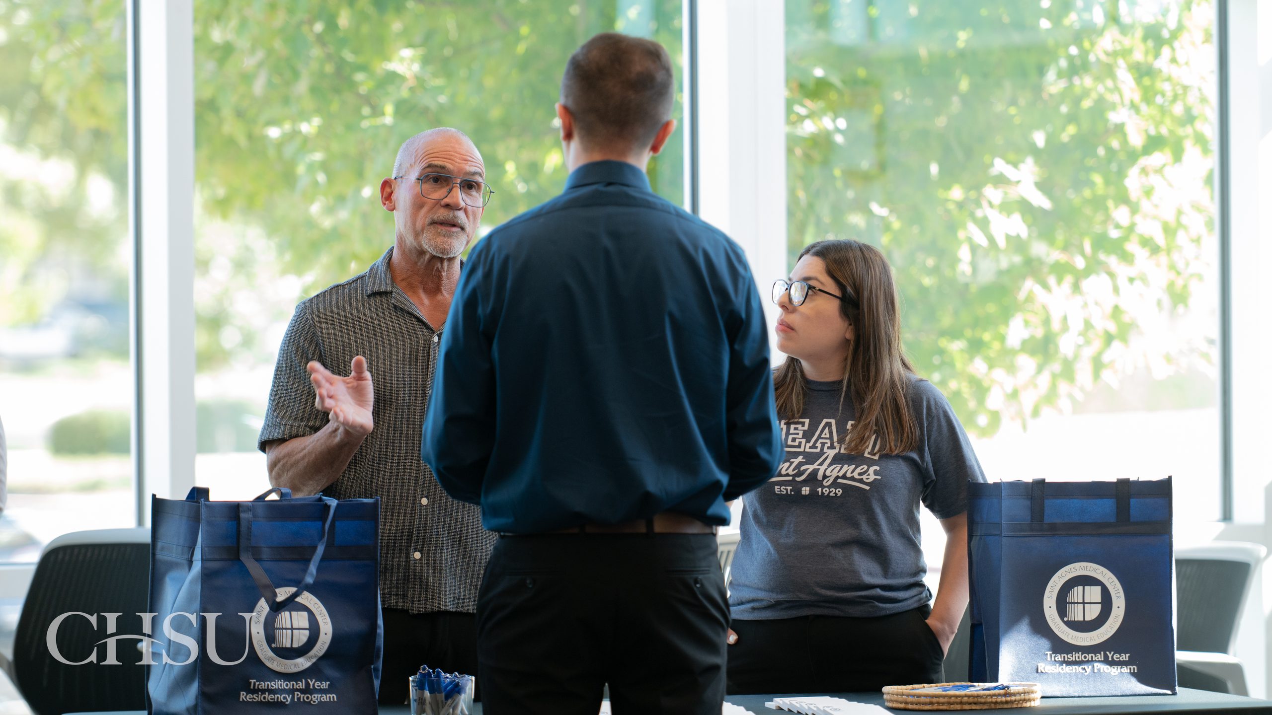 One CHSU medical student speaking with two Saint Agnes Medical Center Transitional Year Residency Program representatives at the CHSU 2026 Residency Fair.
