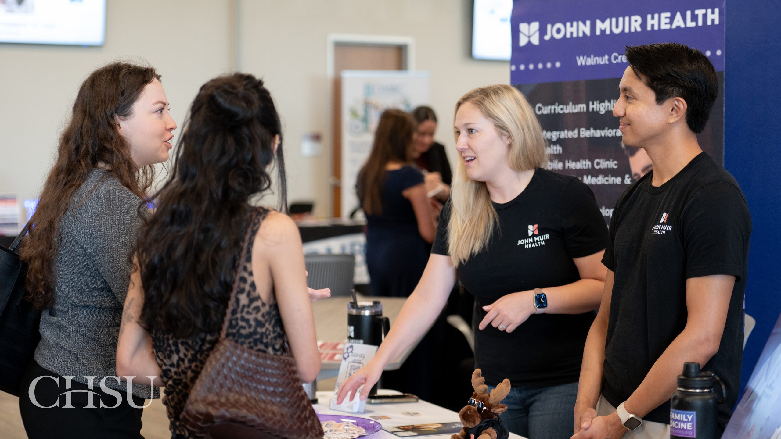 2 CHSU medical students speaking with 2 John Muir Health representatives at the 2026 CHSU-COM Residency Fair.