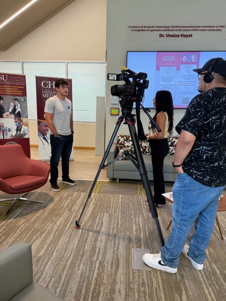 student talking to news reporter behind camera