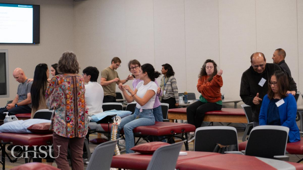 students at tables demonstrating OMM