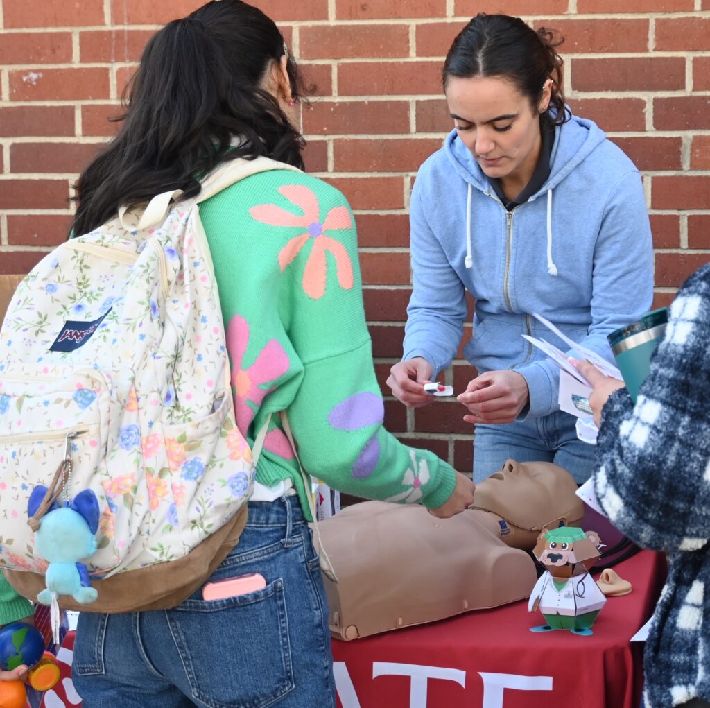 student demonstrating Narcan nasal spray on mannikin