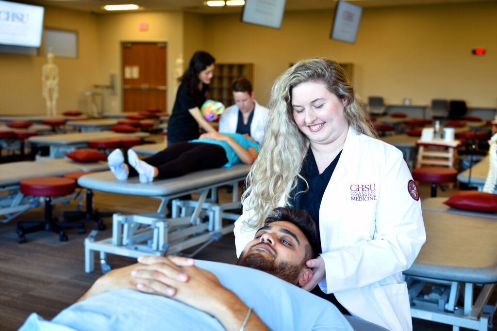 Woman using OMT on male patient simulation