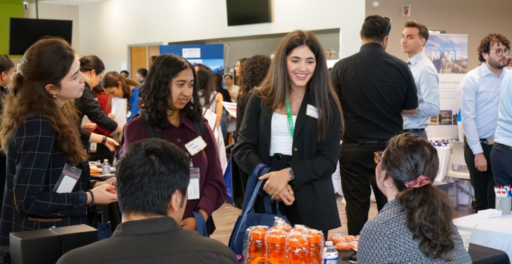 students in dress clothes talking to residency programs at table