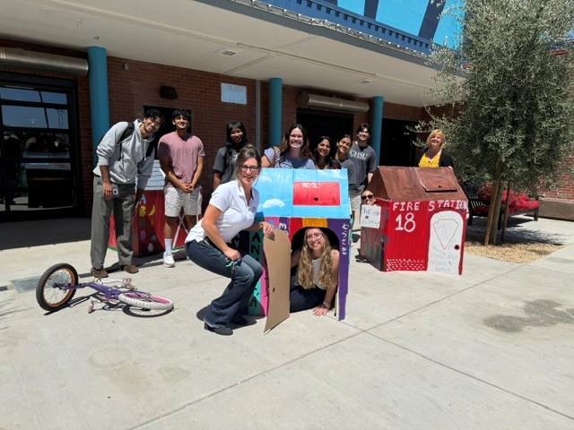 California Health Sciences University students and staff pose with colorful playhouses decorated for donation to Fresno Mission.