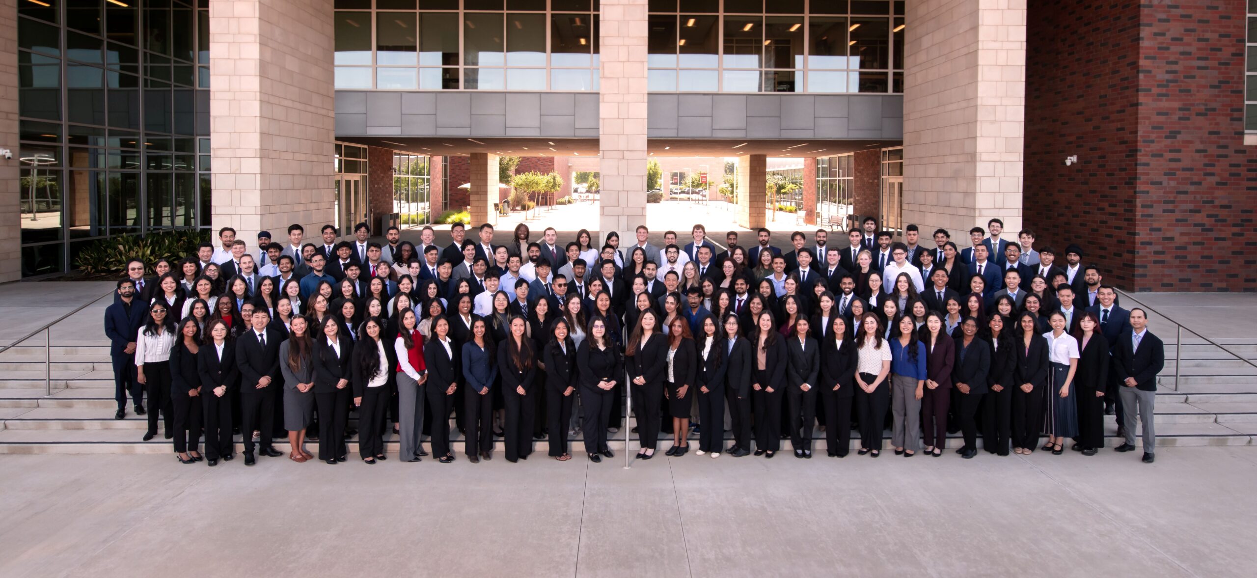 COM Class of 2030 group photo on steps in front of COM building