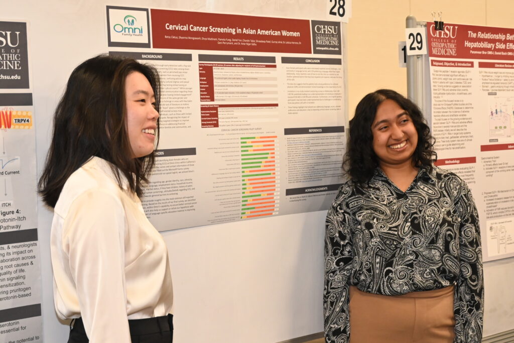 two students in front of research poster for Cervical Cancer Screening in Asian American Women