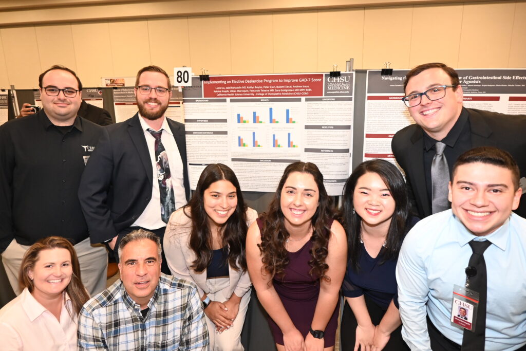 Group of students and faculty posing in front of research poster