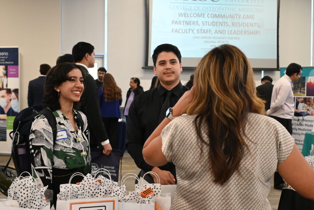 students speaking to representative at booth during Residency Fair
