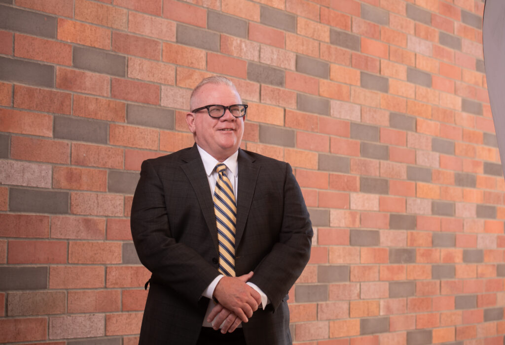 Dr Graneto in front of brick wall