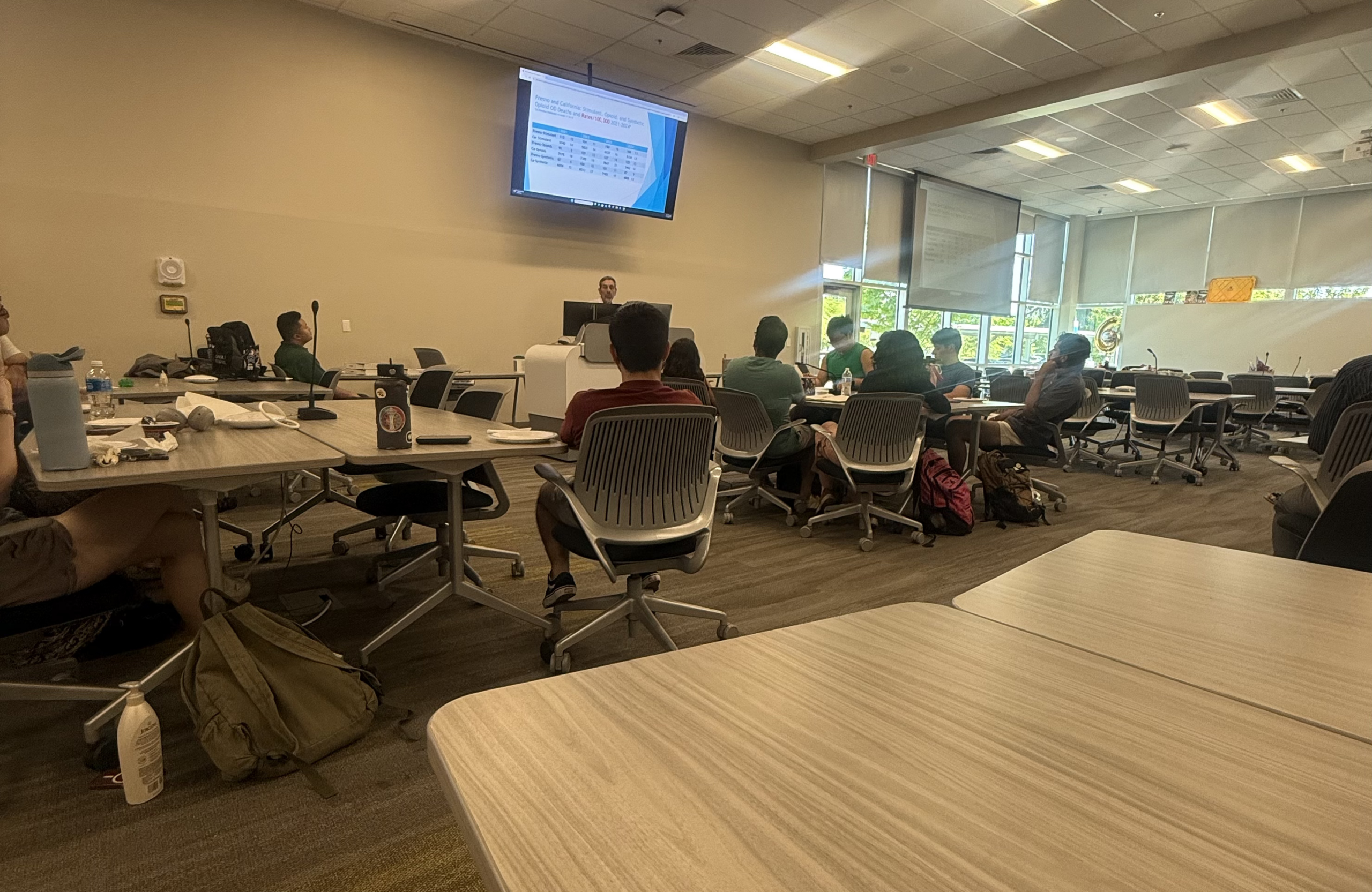 Dr. John Zweifler presents to students in classroom with projector screen