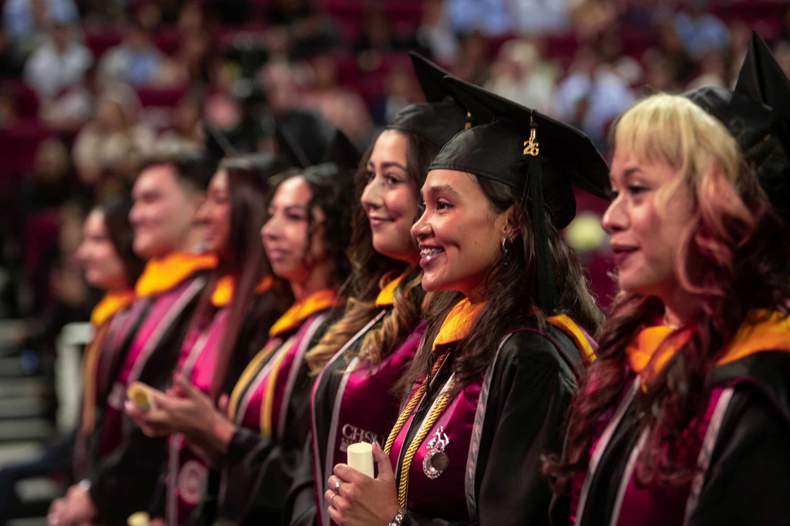 graduates standing wearing regalia at Commencement