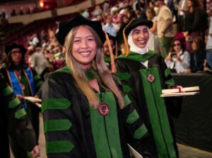 graduates standing wearing regalia at Commencement