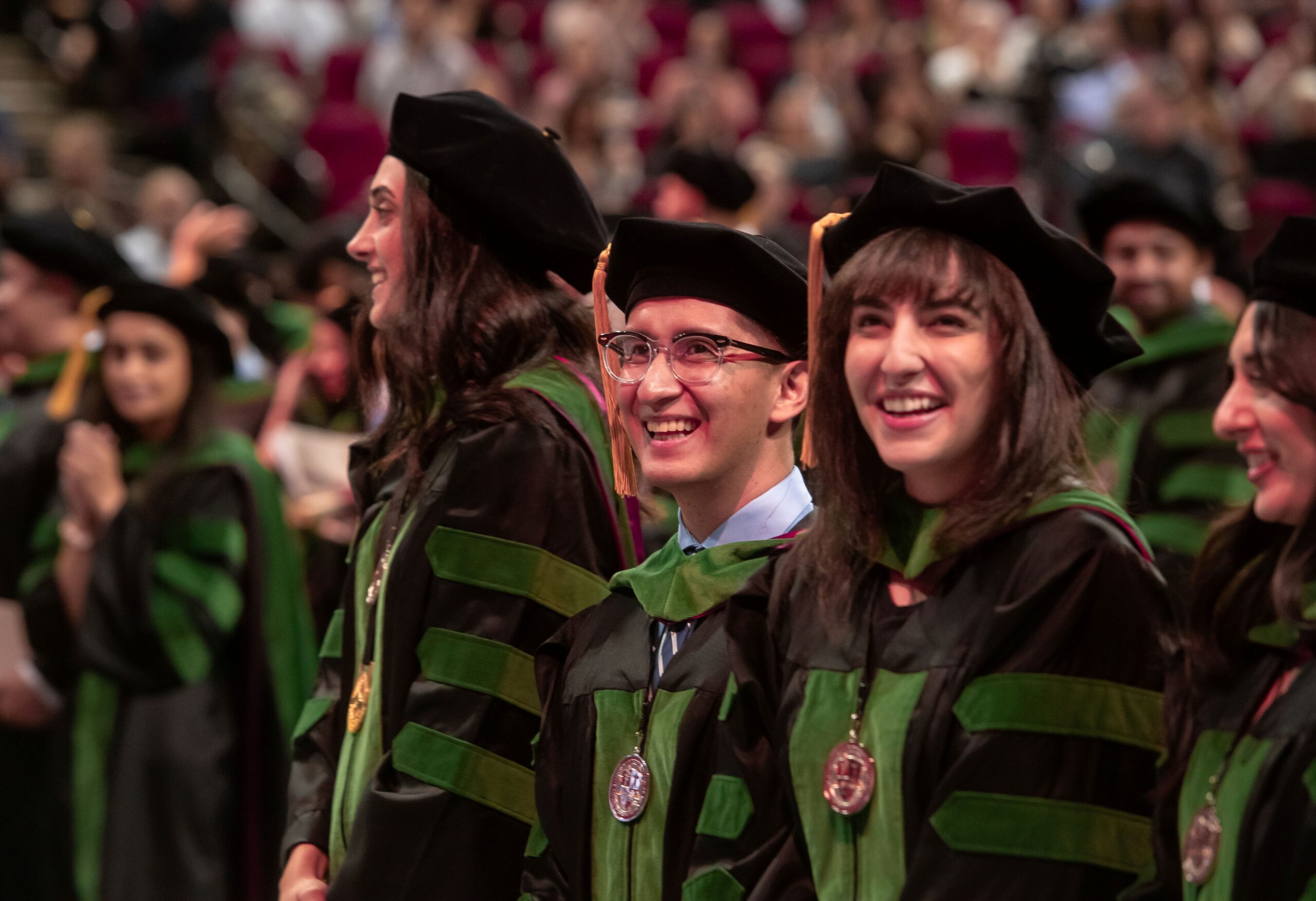 graduates standing wearing regalia at Commencement