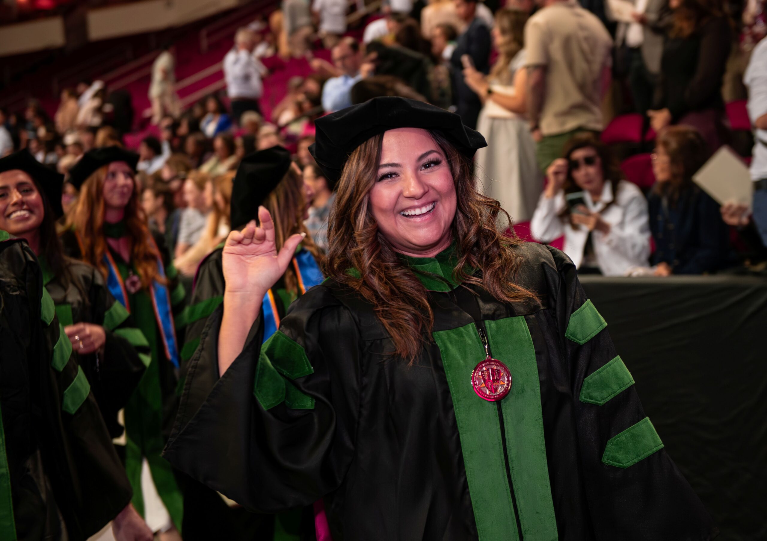graduates standing wearing regalia at Commencement
