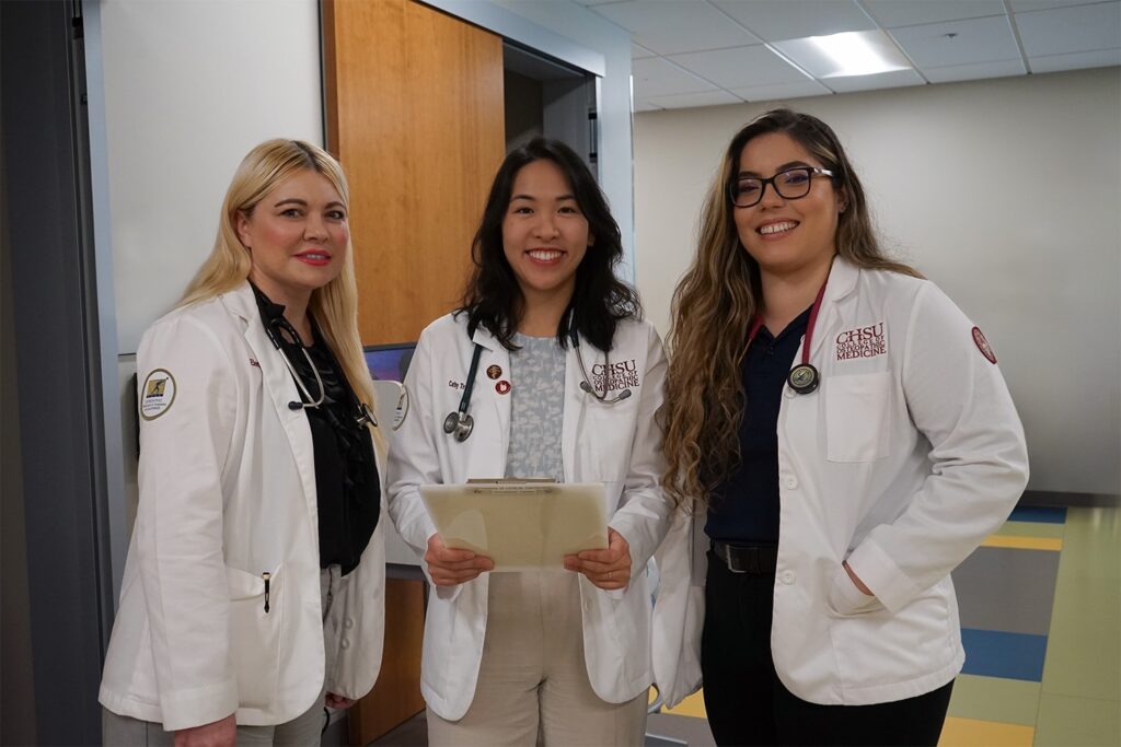three students in white coats