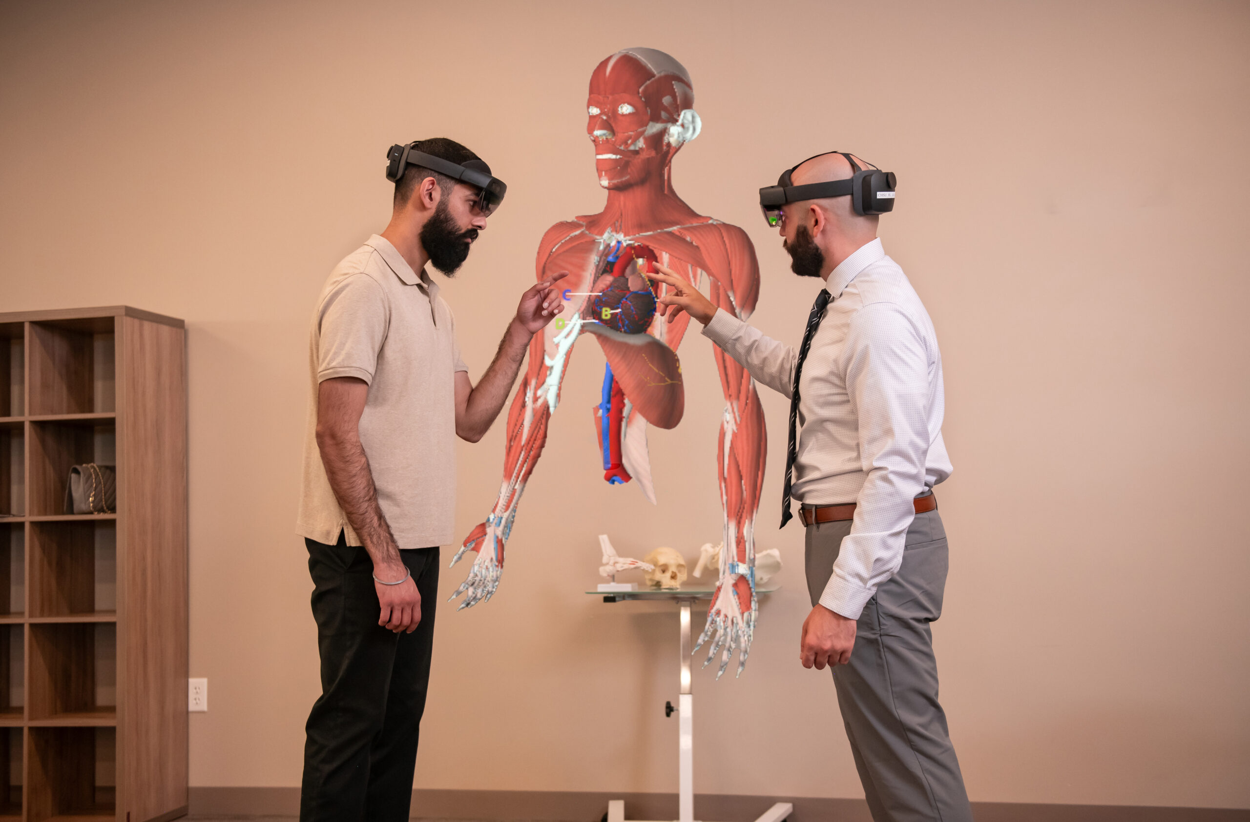 two students with hololens headsets looking at holograph of muscular system