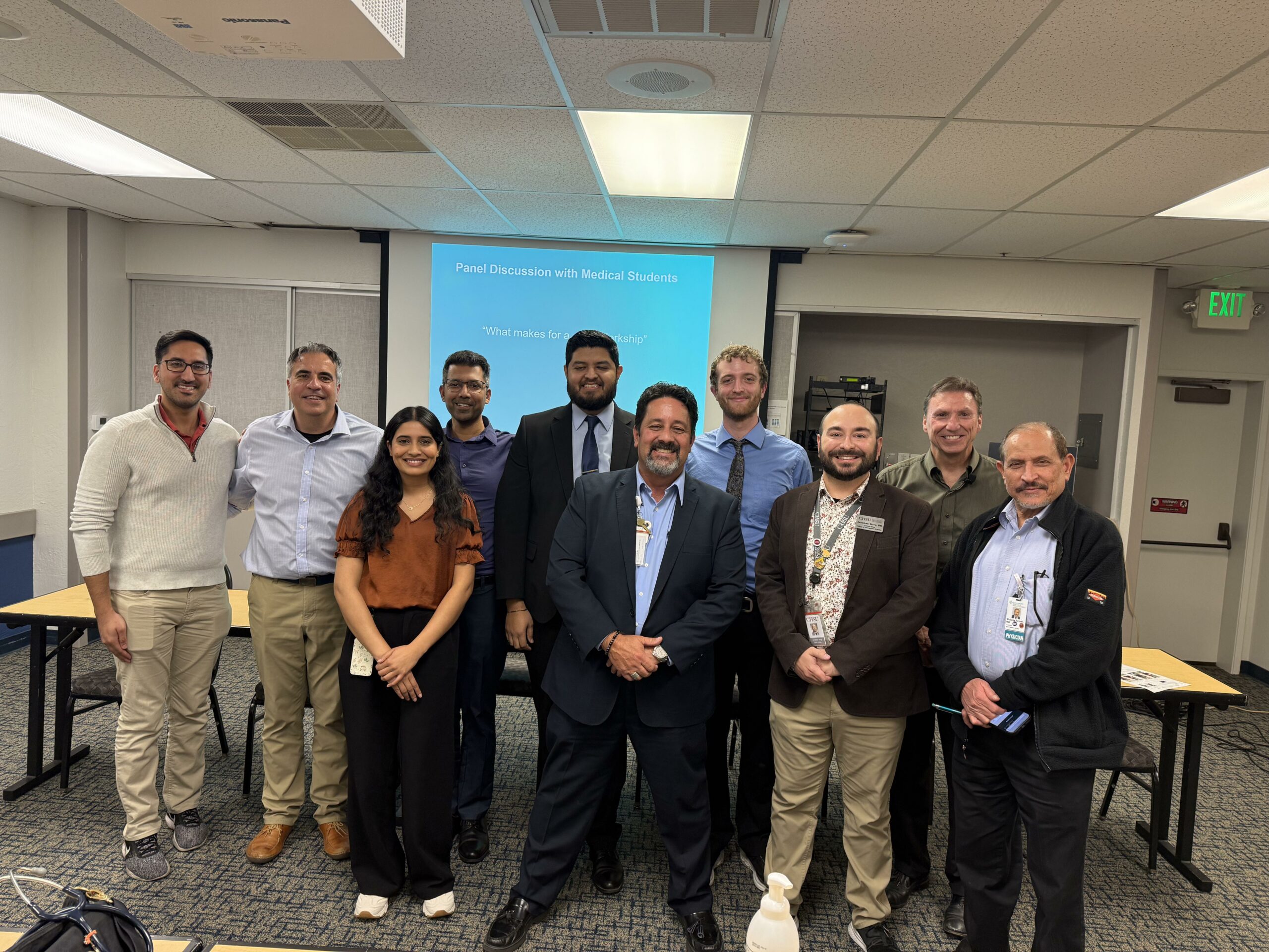 Group of people in room in front of presentation on screen