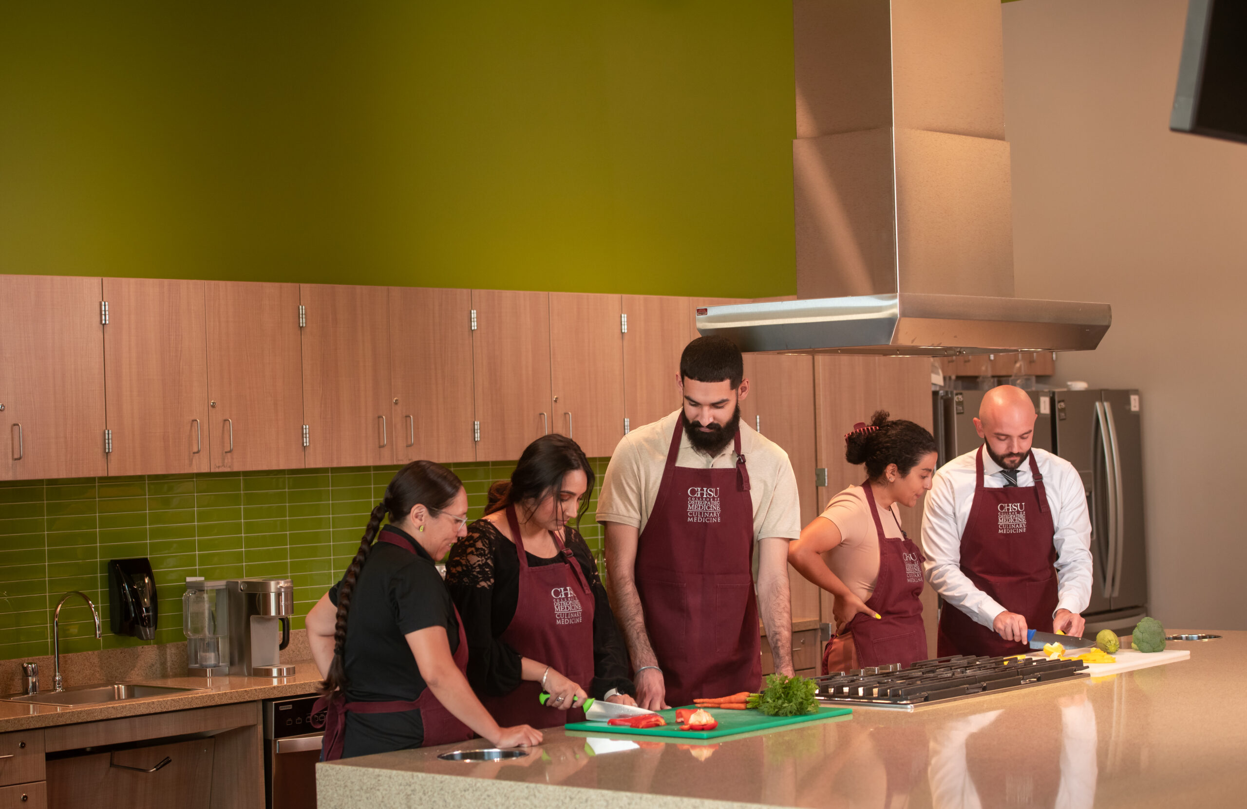 five students prepping food in teaching kitchen