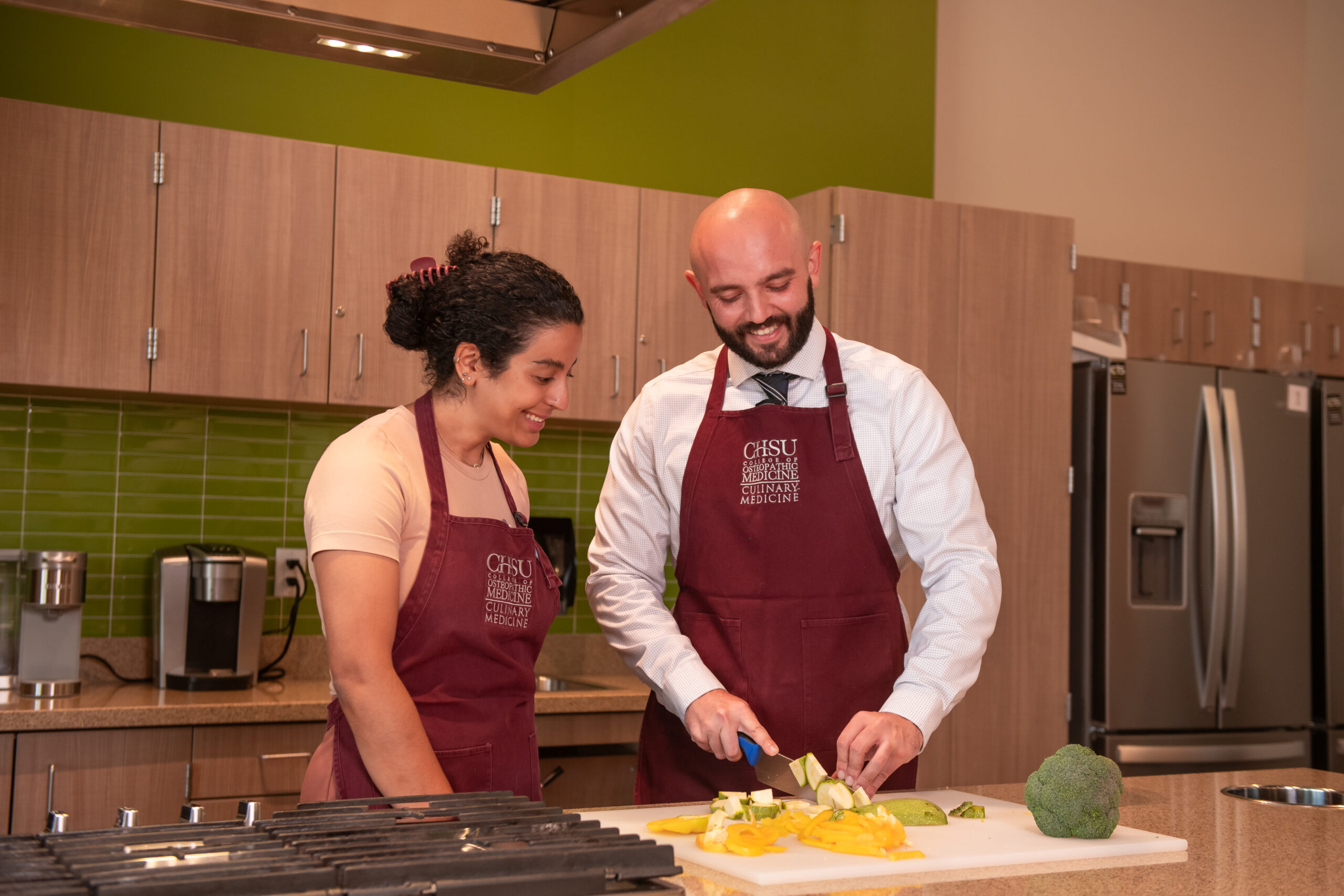 students chopping fresh produce in teaching kitchen
