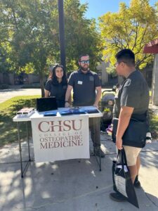 two medical students at table talking to younger student