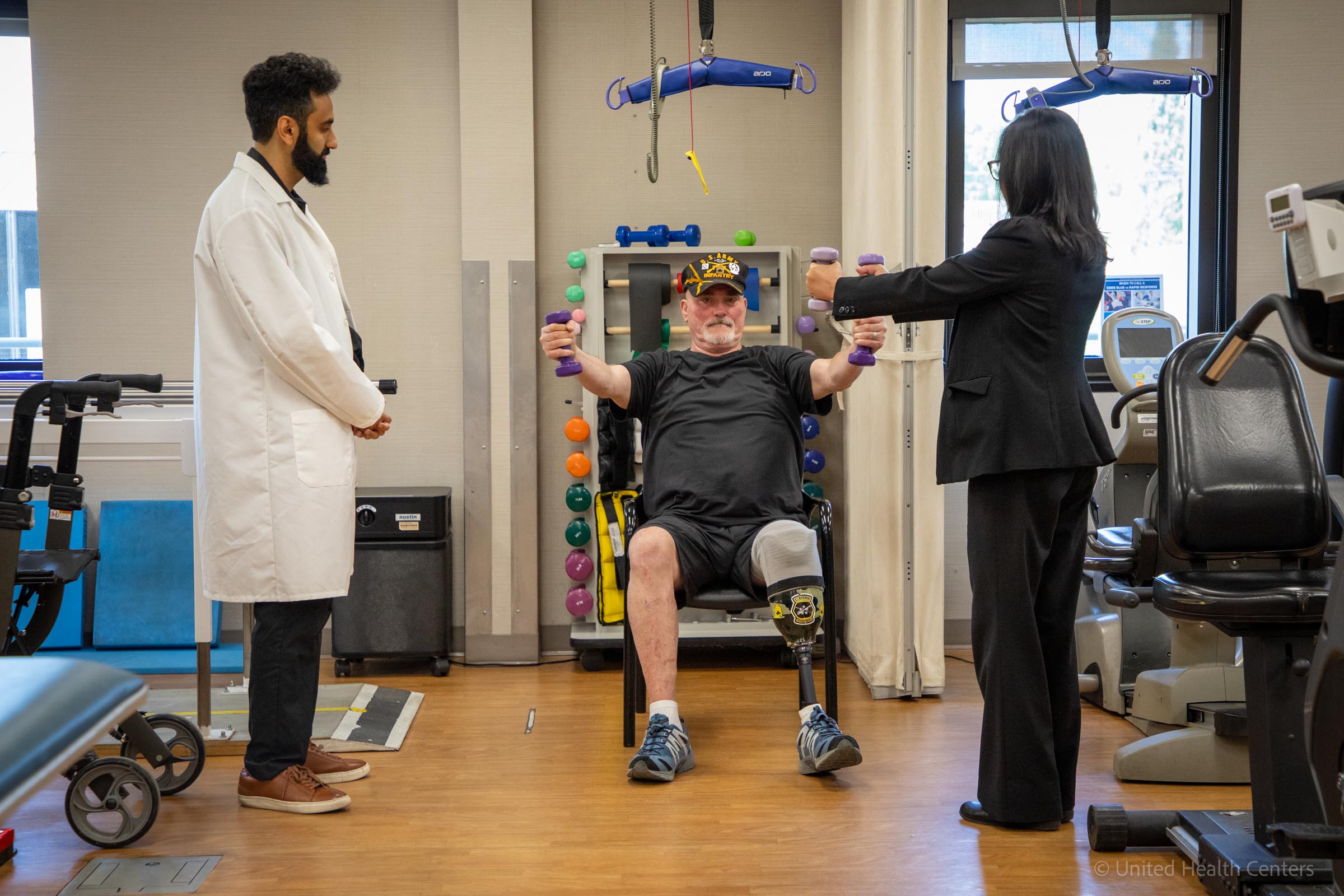 Dr. Molina and Dr. Amireh helping patient with hand weights
