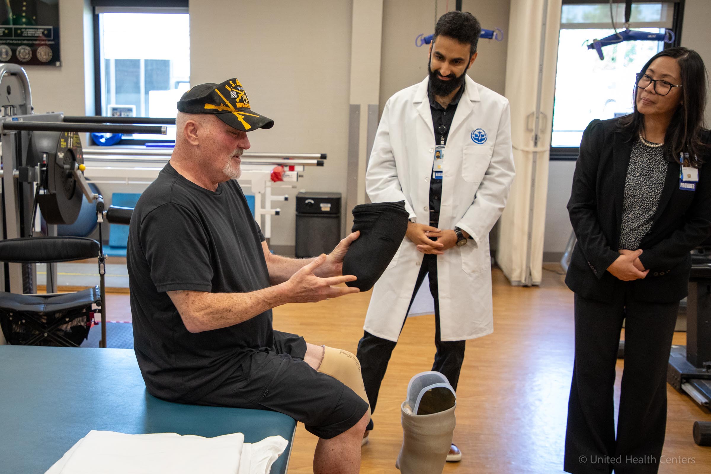Patient holding prosethetic leg talking to doctor