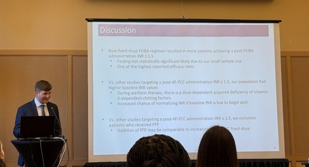 person at podium giving presentation with information on screen