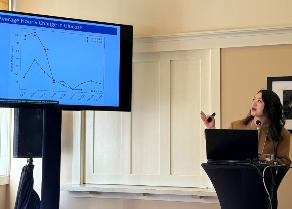 Person giving presentation at podium with information on screen