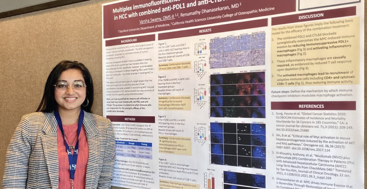 Varsha Swamy standing next to research poster