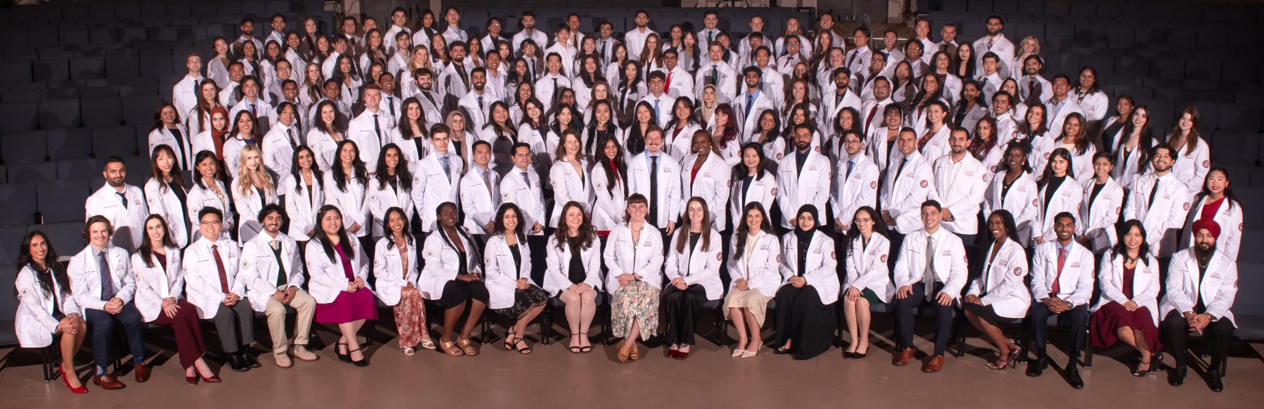 CHSU-COM Class of 2029 medical students in group photo wearing white coats