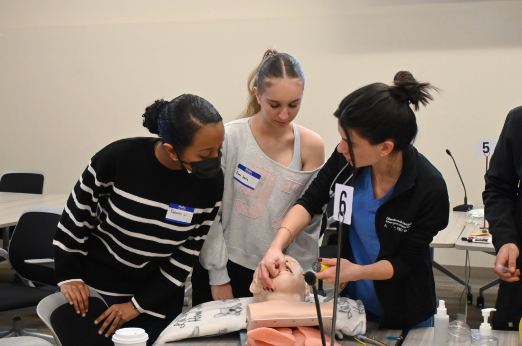 CHSU medical student demonstrating intubation tube insertion on maniken with 2 students watching