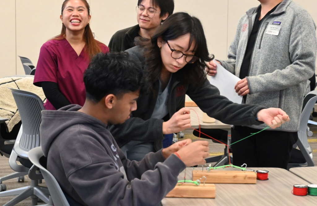 student demonstrating suturing knots to other student