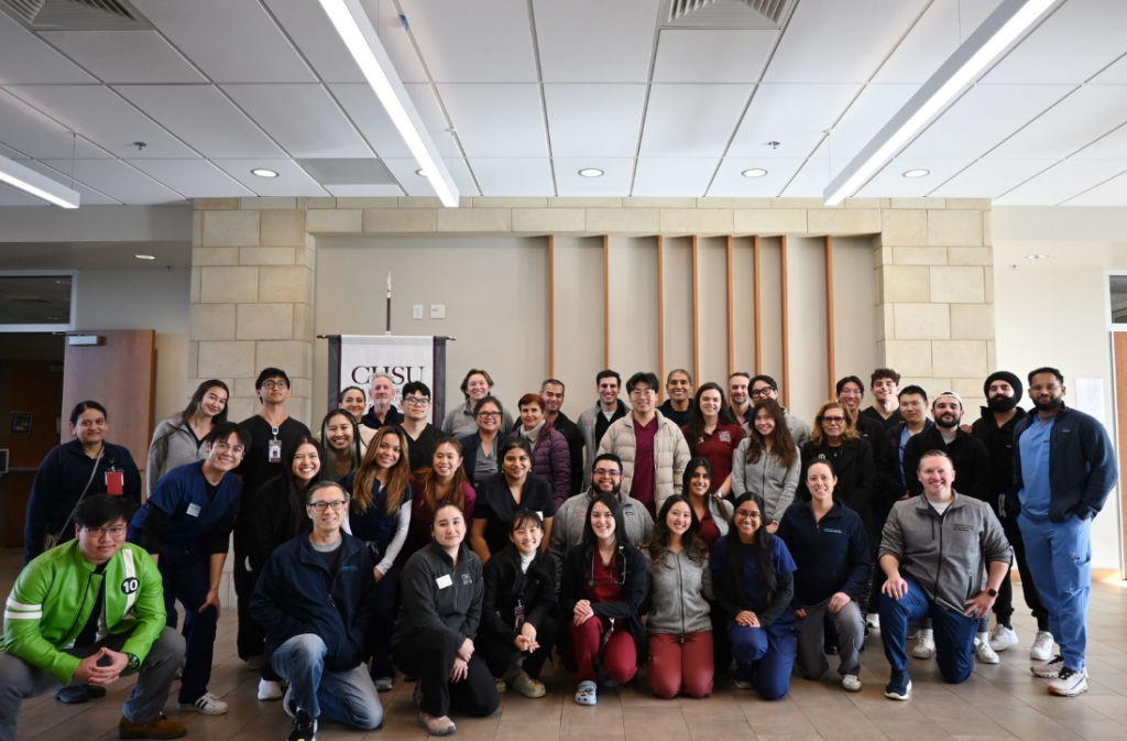 group photo of students and physicians inside CHSU building