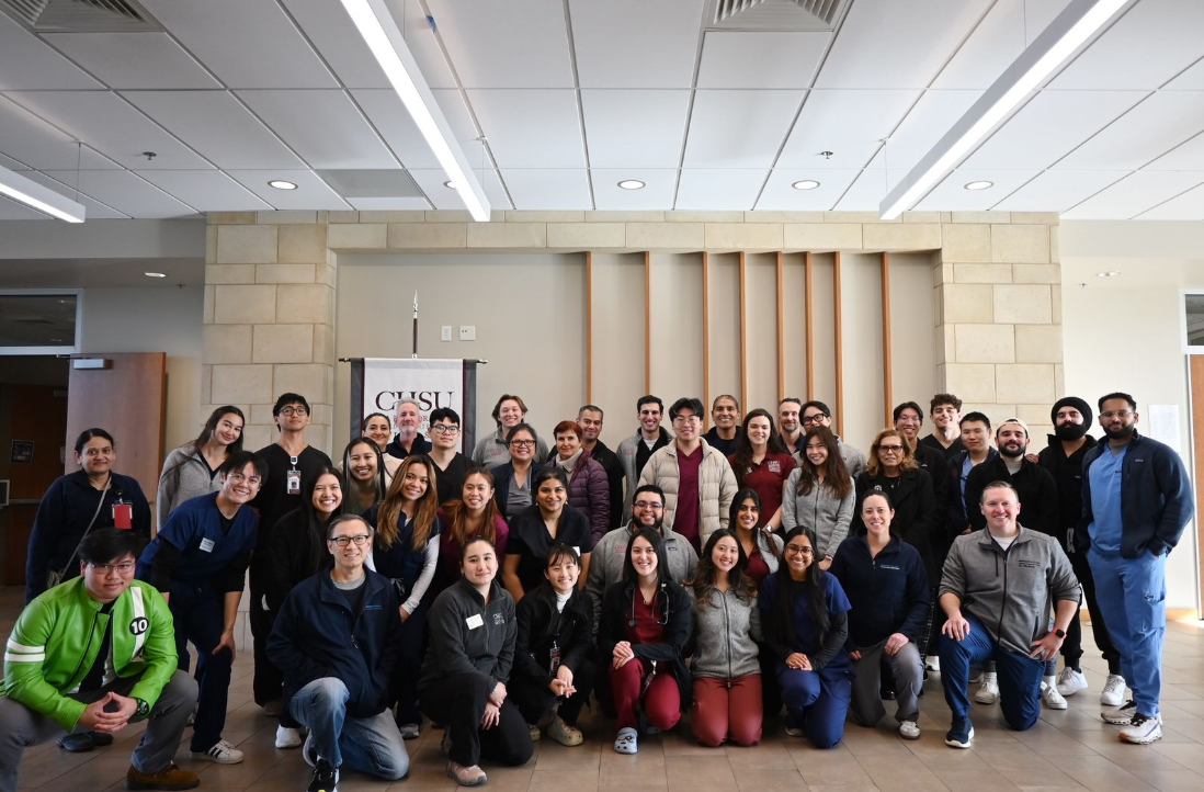 group photo of students and physicians inside CHSU building