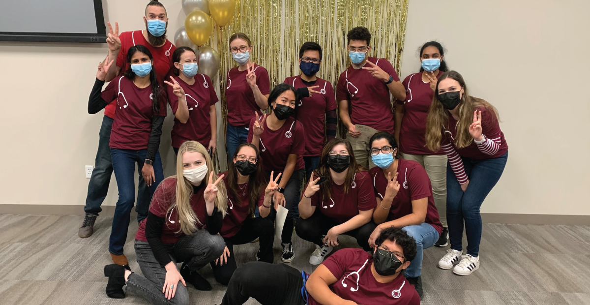 pre-med students in maroon stethoscope t-shirts posing for a group picture