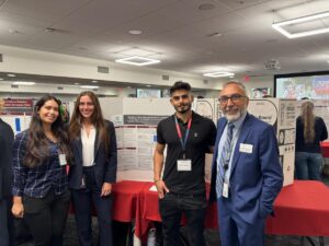 students and faculty in front of research poster