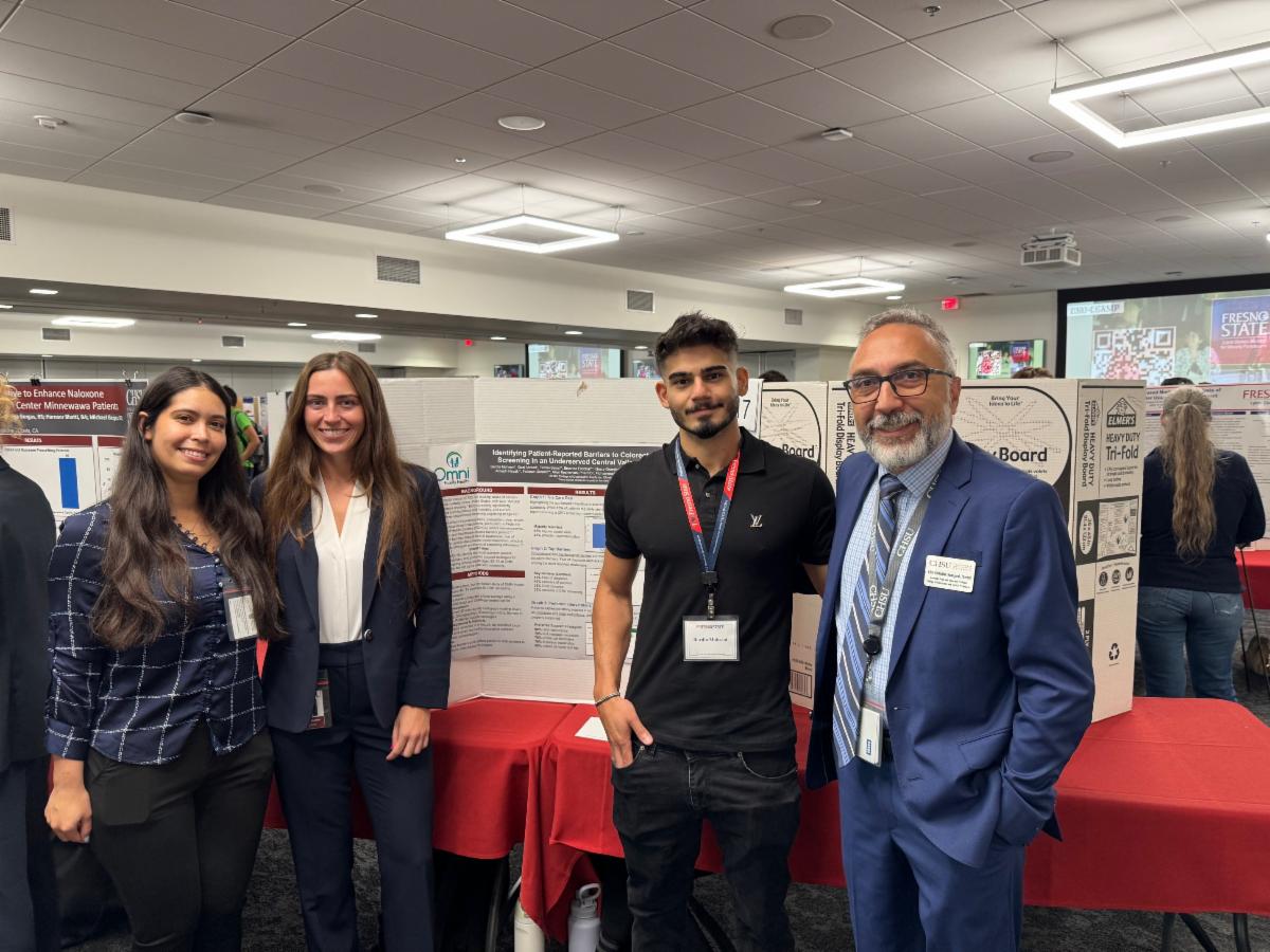 students and faculty in front of research poster
